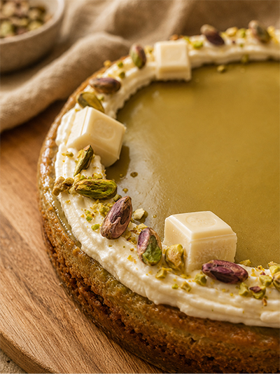 Ambachtelijke pistache cheesecake met romige pistachecrème, witte chocolade en knapperige pistachenoten.